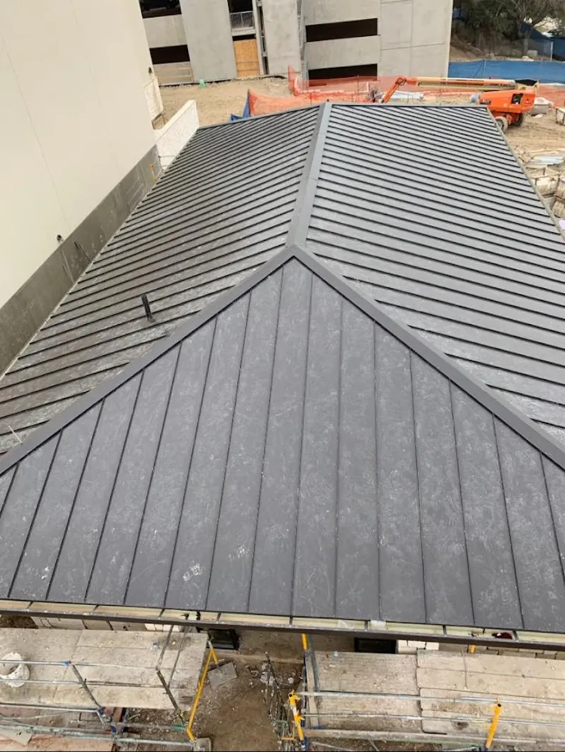 Commercial metal roof construction with crane equipment in DeSoto