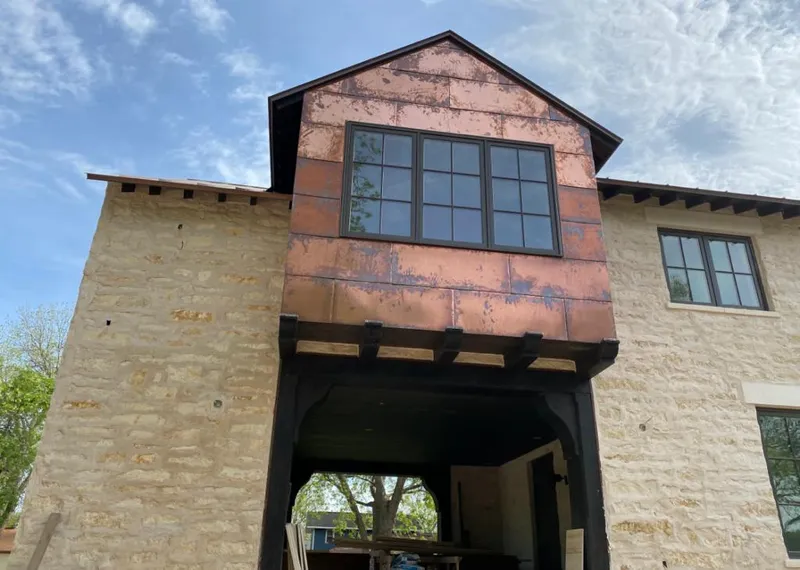 Copper metal panel facade on a stone building for Roof Repair in DeSoto